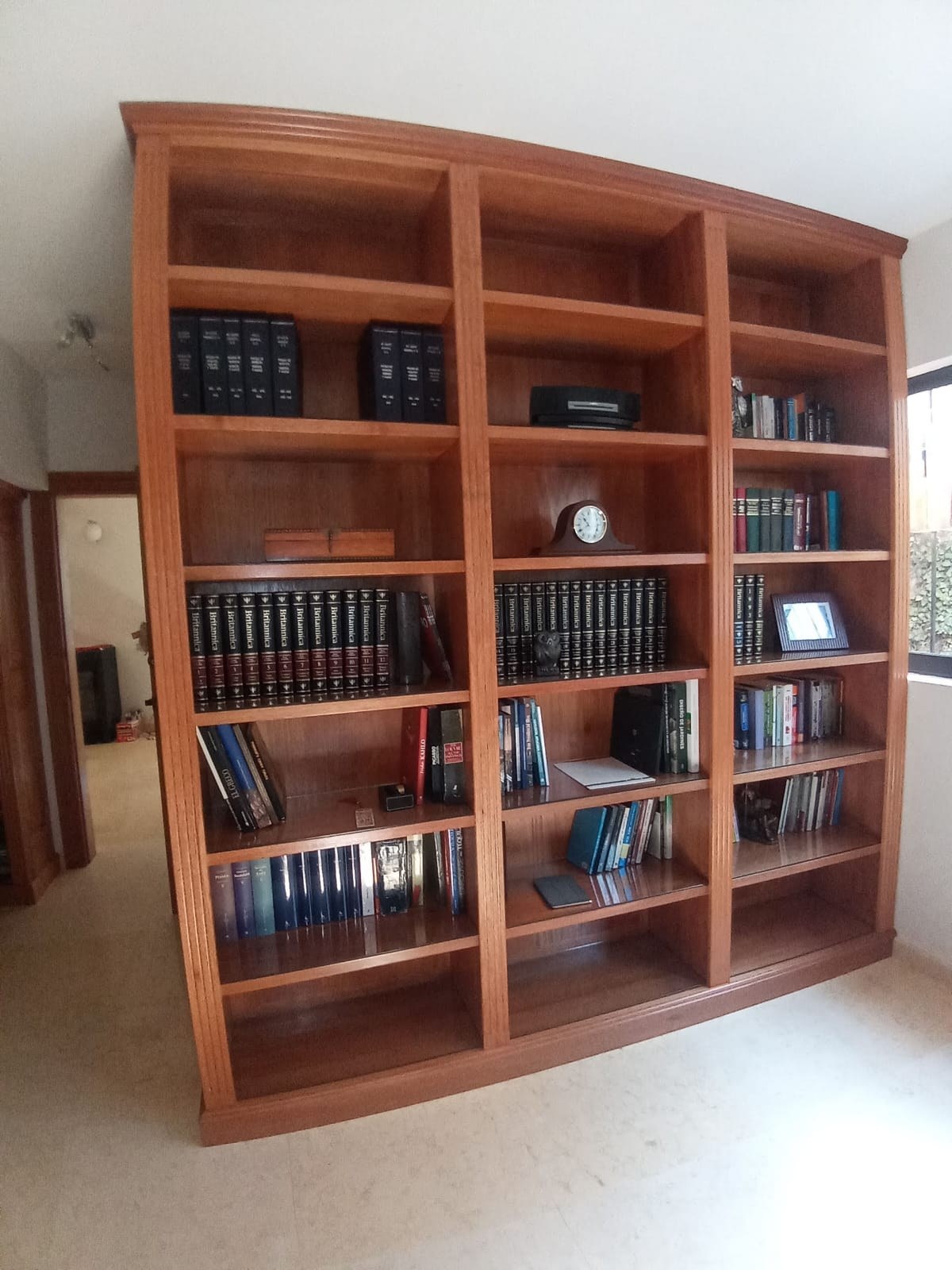 Biblioteca de madera instalada con repisas abiertas