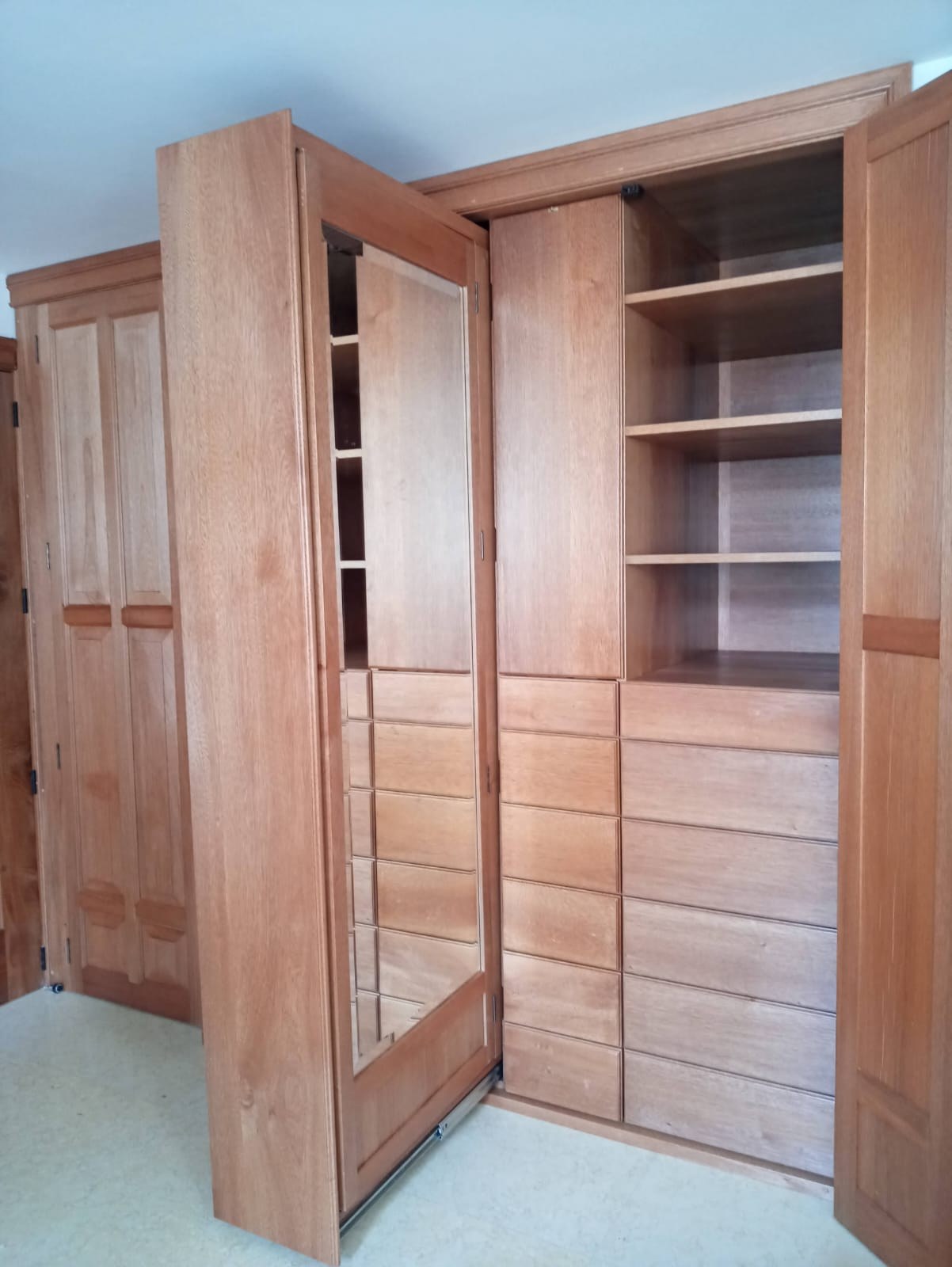 Vestidor de madera con puertas, cajones, repisas y espejo