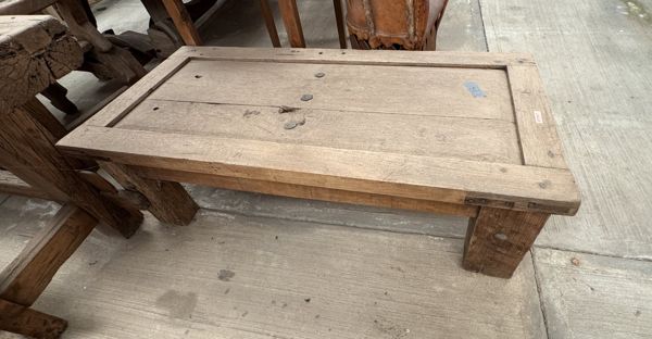 Mesa baja rectangular de madera con tablero de tablas rodeado por un marco ancho y patas robustas.